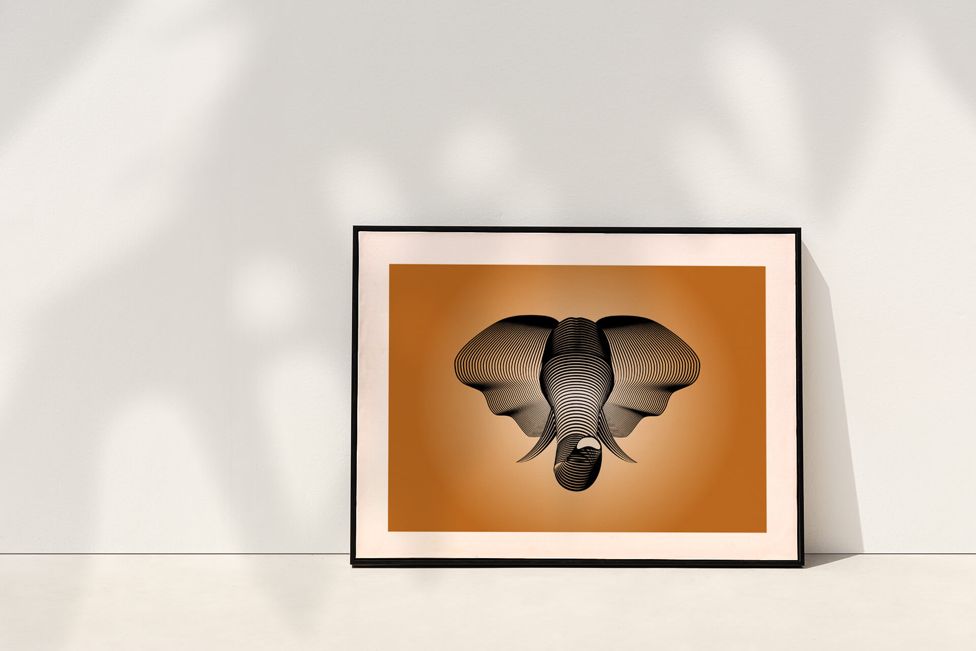Illustration de tête d'éléphant encadrée posée au pied d'un mur blanc